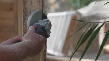 A man is using a power tool to cut wood. Concept of productivity and hard work. Slow motion video