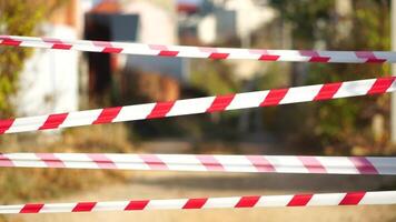 Red and white warning tape swinging in the wind. Protection sign. Don't cross the line. Red White caution tape pole fencing is protects for No entry. Backdrop without people, empty street. video