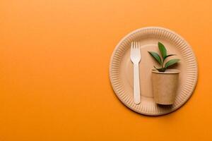 set of empty reusable disposable eco-friendly plates, cups, utensils on light white colored table background. top view. Biodegradable craft dishes. Recycling concept. Close-up photo