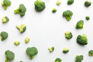 Flat lay composition with fresh green broccoli frame eith copy space on light background photo