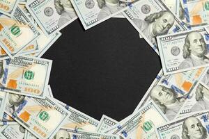 Frame of one hundred dollar bills with empty space for your design. Top view of business concept on black background with copy space photo