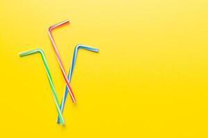 Drinking straws for party on Colored background. Top view of colorful plastic disposable straws for summer cocktails. different straws for juice with copy space photo