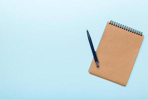 school brown notebook on a colored background, spiral craft notepad on a table Top view photo