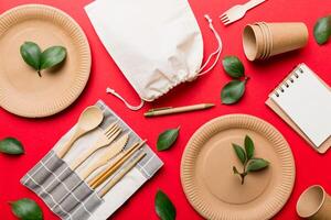 set of empty reusable disposable eco-friendly plates, cups, utensils on light white colored table background. top view. Biodegradable craft dishes. Recycling concept. Close-up photo