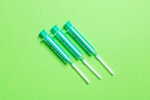 Top view of medical syringes on colorful background with copy space. Injection equipment concept photo