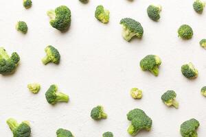 Flat lay composition with fresh green broccoli frame eith copy space on light background photo
