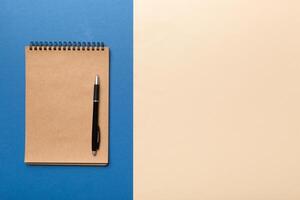 school brown notebook on a colored background, spiral craft notepad on a table Top view photo