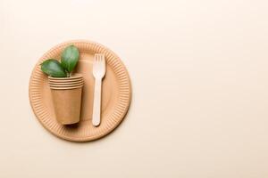 set of empty reusable disposable eco-friendly plates, cups, utensils on light white colored table background. top view. Biodegradable craft dishes. Recycling concept. Close-up photo