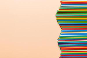 Heap of colorful plastic drinking straws on Colored background, flat lay. Copy Space for text photo