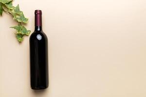 One Bottle of red wine on colored table. Flat lay, top view wth copy space photo