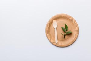 set of empty reusable disposable eco-friendly plates, cups, utensils on light white colored table background. top view. Biodegradable craft dishes. Recycling concept. Close-up photo