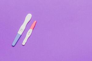 Colored Pregnancy test on colored background, top view with copy space photo