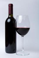 Glass of red wine and a bottle on colored table. Flat lay, top view wth copy space photo
