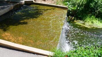 A small sluice gate or weir is draining water photo