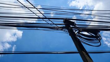 Electrical poles and electrical wires on the side of the road There is a blue sky and clouds in the background photo