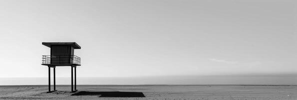 A minimalistic view of a lone lifeguard tower overlooking a vast empty sea. Black and white art. photo