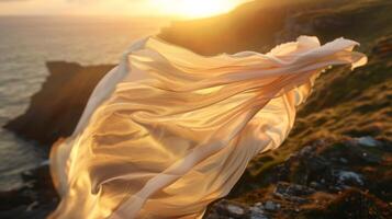 Against the setting sun the fabric creates an ethereal effect as it glides and sways over the edge of the cliff photo