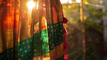 A traditional sari with hues of red green and gold seeming to float on its own as it hangs on a clothing line photo