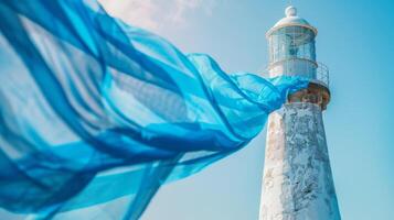 The gentle ocean breeze causing a soft blue fabric to dance around the strong stoic structure of a lighthouse photo