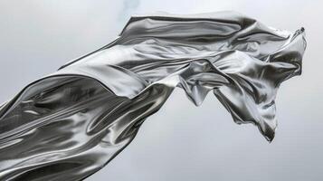 A sleek silver cloth stretches out like a desperate hand struggling to maintain its tenuous hold against a fierce monsoon wind photo