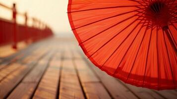 The bright red fabric of a parasol billows in the breeze offering a burst of color against the neutral tones of the boardwalk photo
