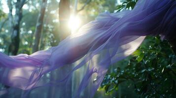 Against the backdrop of towering trees a lavender fabric catches the sunlight and sways gracefully in the gentle breezes of the rainforest photo