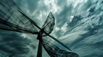 Against the backdrop of a cloudy sky a swath of fabric seems to come alive as it whips and swirls in the wind a the windmills photo