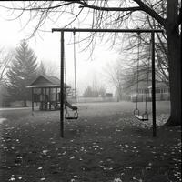With no children giggling or shouting the playground feels barren and desolate. Black and white art. photo