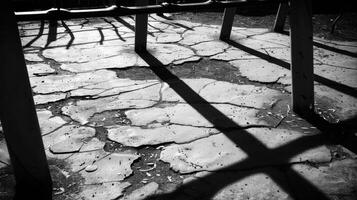 The plastic monkey bars cast ominous shadows on the cracked pavement. Black and white art. photo