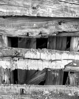 The wooden frame of a chicken coop is riddled with knots and cracks highlighting its age. Black and white art. photo