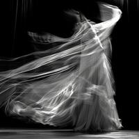 The wind takes hold of a curtain transforming it into a work ofart.t with its graceful movements. Black and white art. photo