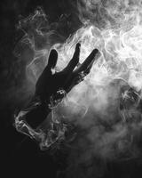 The silhouette of a hand can be seen in a hazy mirror manipulating the smoke swirling in front of it. Black and white art. photo