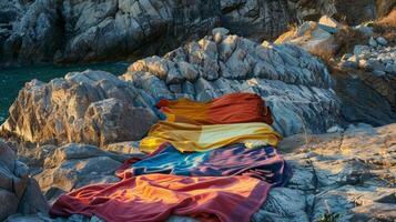 Several colorful beach towels lay strewn about the rocky shore providing a comfortable spot for the group to relax photo
