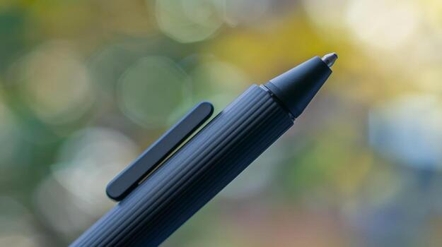 The tip of a smart pen is captured in detail showcasing its precision and fine point. The charging port is visible at the top of the pen right below the click button photo