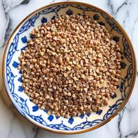 A sful of buckwheat groats showcasing its unique triangular shape and grainy texture perfect for adding to soups and stews for a nutrient boost photo