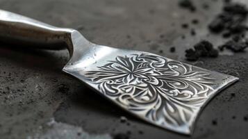 The intricate pattern on the handle of this trowel adds a touch of elegance to its strong and functional design photo