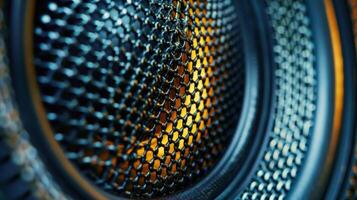 A closeup of a speakers tweeter reveals its intricate mesh design and powerful magnet designed to produce high frequencies with amazing precision photo