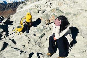 Young caucasian woman trekker resting on Chola pass in Himalayas high altitude feeling low oxygen level affects of dizziness and weakness photo