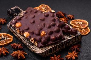 Black bitter chocolate with whole hazelnuts, candied fruits and mint photo