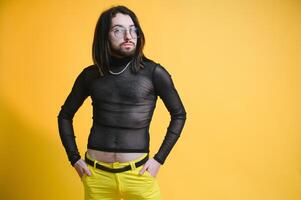 Young gay man is standing in the studio and posing for a camera. photo