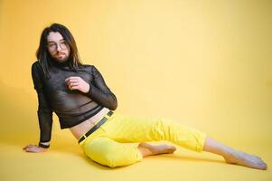 Young gay man is standing in the studio and posing for a camera. photo