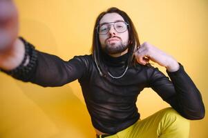 Young gay man is standing in the studio and posing for a camera. photo