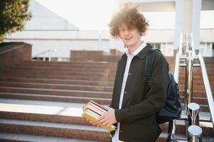 Portrait of a cheerful college student standing outside with back photo