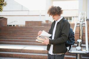 Excited student having break between classes near university, smiling to camera outdoors photo