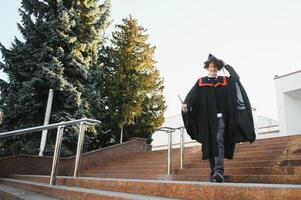 Excited male student in mantle scream graduate from university finish course studying. Happy man triumph holding college diploma in hands overjoyed with high school graduation. photo