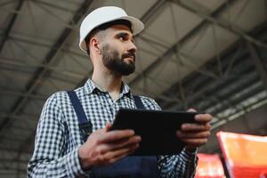 Factory technician working using digital tablet at factory warehouse photo