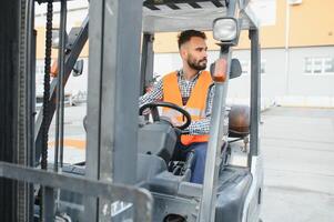 Waving forklift driver in the warehouse of a haulage company while driving forklift photo