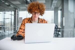 male programmer wear spectacles for eyes protection while working on freelance via laptop computer,clever student watching tutorial on netbook. photo