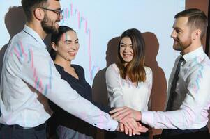 Group of business people working at modern office.Technical price graph, red and blue candlestick chart and stock trading computer screen background. Double exposure. Traders analyzing data photo