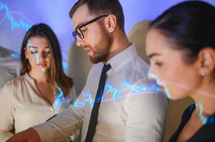 Group of business people working at modern office.Technical price graph, red and blue candlestick chart and stock trading computer screen background. Double exposure. Traders analyzing data photo